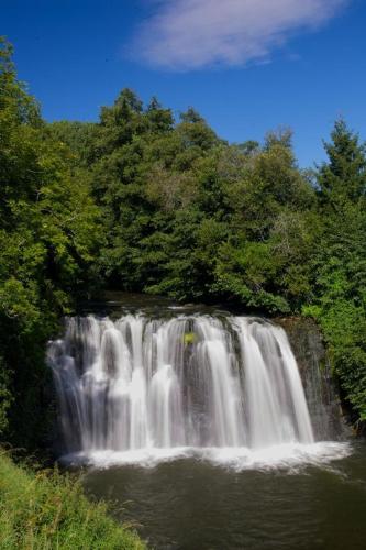 a waterfall in the middle of a forest at L OUSTALOU MAISON D HOTES DE CHARME EN AUVERGNE PISCINE PRIVEE CHAUFFéE in Saint-Nectaire