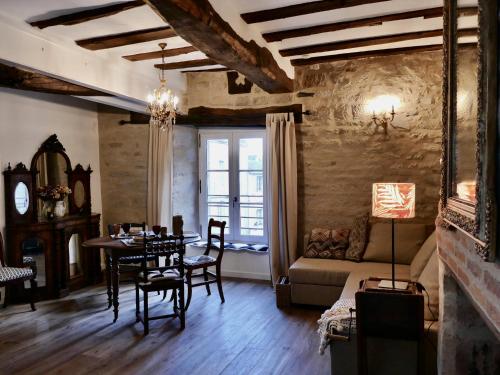 a living room with a table and chairs and a couch at HENRI& HENRIETTE le studiolo d'HENRI in Vannes