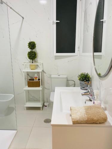 a white bathroom with a sink and a mirror at Solymar Beach Premium in Málaga