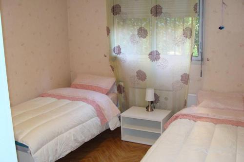 une chambre avec deux lits jumeaux et une fenêtre dans l'établissement T4 proche Hypercentre, box auto privé et loggia, à Toulouse