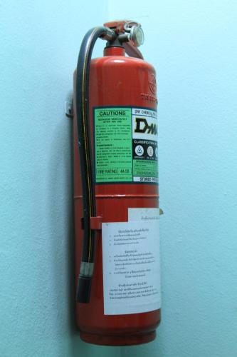 a red fire extinguisher hanging on a wall at Swan inn 2 Nana in Bangkok