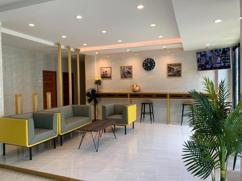 a lobby with chairs and a bar in a building at Money Grand Home in Ban Don Muang