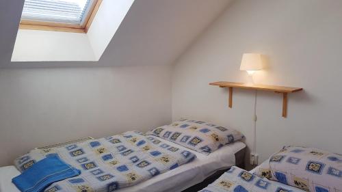 2 camas en una habitación pequeña con ventana en Apartments Iris en Liptovský Mikuláš