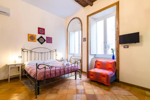 um quarto com uma cama e uma cadeira vermelha em LA CASA DI NONNA LELLA 1 em Salerno