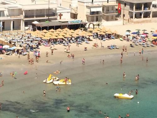 a group of people on a beach with umbrellas at Blue Sea Apartment in Torre Canne