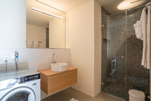 een badkamer met een wasmachine en een douche bij Edelweiss Stenna Cavorgia in Flims