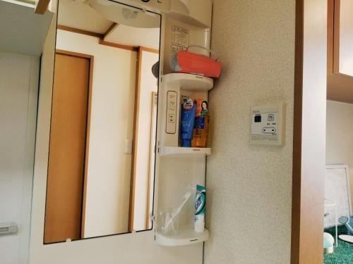 um espelho pendurado numa parede num quarto em Takaraboshi room 101 Sannomiya10min em Kobe