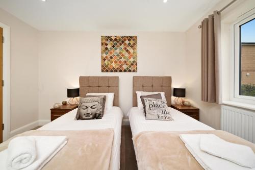 Rúm í herbergi á London Heathrow Living Serviced Apartments by Ferndale