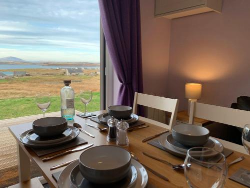 a dining room table with a view of the ocean at Hebridean Holiday Cabins in Breasclete