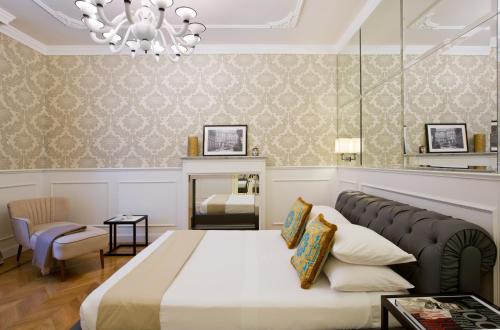 a bedroom with a large bed and a chandelier at Duomo Rooms in Milan