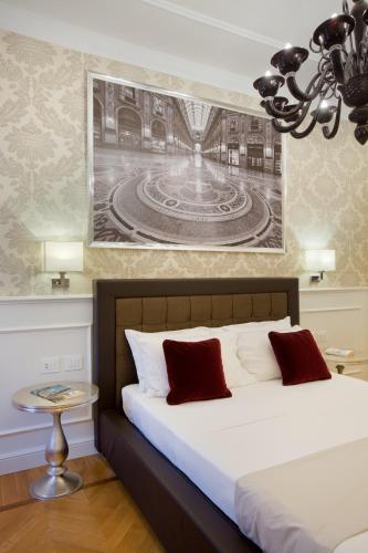 a bedroom with a bed and a picture on the wall at Duomo Rooms in Milan