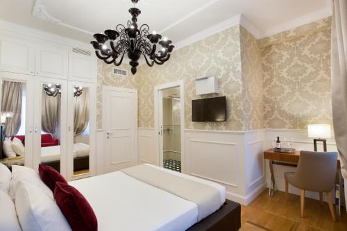 a bedroom with a bed and a desk and a chandelier at Duomo Rooms in Milan
