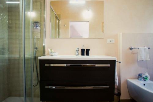 a bathroom with a sink, mirror and bath tub at B&B Casa Faccioli in Bologna
