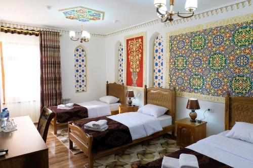 Llit o llits en una habitació de Bukhara Baraka Boutique Hotel