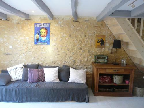 Le Masにあるgîtes les 7 roches 4 personnesのソファと壁のあるリビングルーム