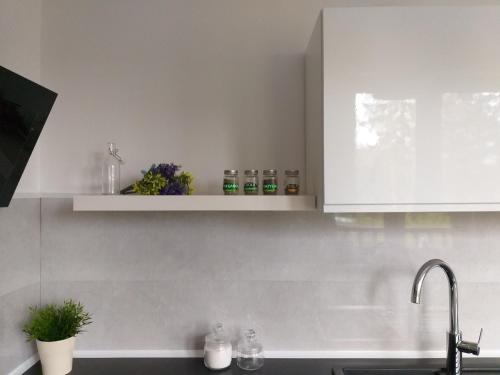 a kitchen with white cabinets and a sink at Rowy Apartament.b5 in Rowy