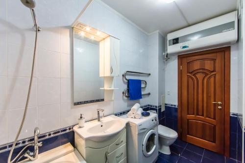 a bathroom with a sink and a toilet and a mirror at Комфортная двухкомнатная квартира возле метро Академгородок in Kyiv