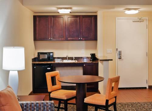 a kitchen with a table and chairs in a room at Holiday Inn Ardmore by IHG in Ardmore
