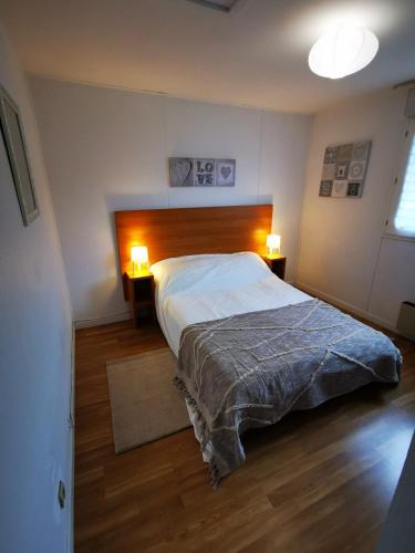une chambre avec un grand lit et deux lampes dans l'établissement Maisonnette 5 personnes dans résidence avec piscine, à Soustons