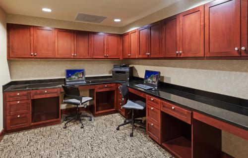 an office with two laptops on a desk with cabinets at Holiday Inn Ardmore by IHG in Ardmore