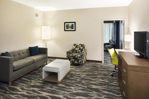 a living room with a couch and a desk at Holiday Inn Augusta West I-20 by IHG in Augusta