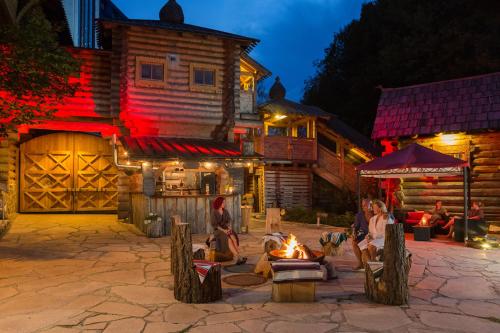 a group of people sitting around a fire in front of a building at Hotel Am Bühl in Eibenstock