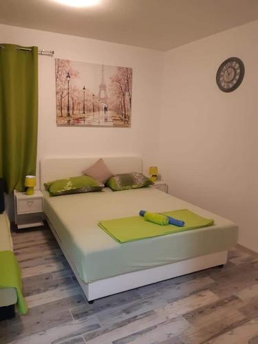 ein Schlafzimmer mit einem Bett mit einer Uhr an der Wand in der Unterkunft APARTMANI PAVLOVIC in Zelenika