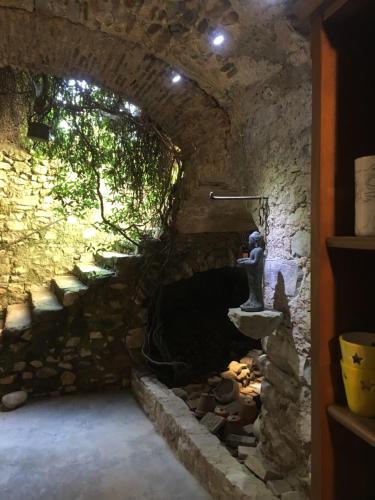 un tunnel en pierre avec une cheminée dans une pièce dans l'établissement L’insolite, à Meyrannes