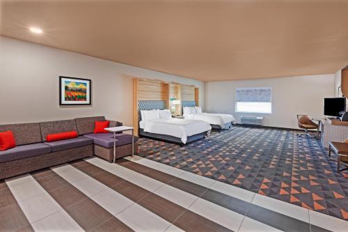 a hotel room with a couch and a bed at Holiday Inn - Amarillo East by IHG in Amarillo