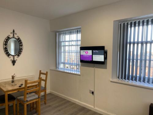 a dining room with a table and a tv on the wall at Westgate Apartments in Newcastle upon Tyne