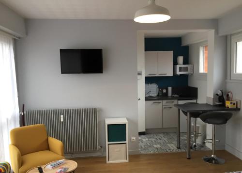 a living room with a table and a yellow chair at SAFARI DREAM in Lille