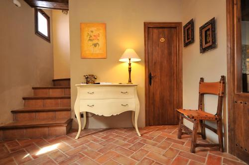a room with a dresser and a chair and stairs at Els Canterers in Miravet