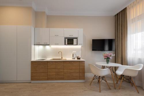 a kitchen with a sink and a table with chairs at Apartamenty w Klaudynie in Klaudyn