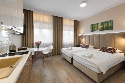 a hotel room with a bed and a kitchen at Apartamenty w Klaudynie in Klaudyn