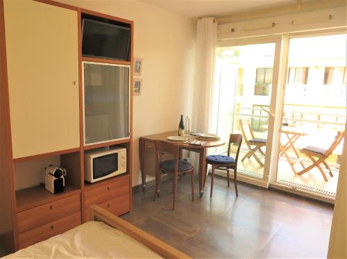 a bedroom with a bed and a table with a microwave at Les Jasmins in Beaulieu-sur-Mer