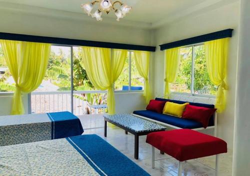 1 Schlafzimmer mit 2 Betten, einem Sofa und Fenstern in der Unterkunft SweetWater Resort in Zamboanguita