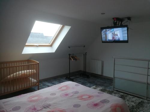 a bedroom with a bed and a tv on the wall at Gite d' angel in Kermaria-Sulard