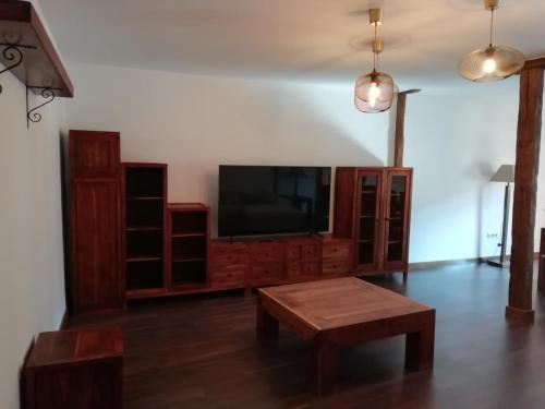a living room with a tv and a coffee table at Apartamentos rurales 'Los Soportales' in Tendilla