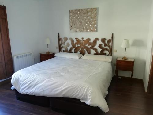 a bedroom with a large bed with a wooden headboard at Apartamentos rurales 'Los Soportales' in Tendilla
