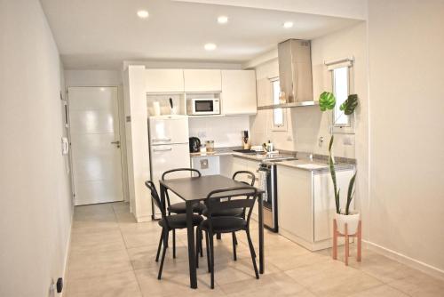 a kitchen with a table and chairs in a room at Luminosos y modernos departamentos en Rosario in Rosario