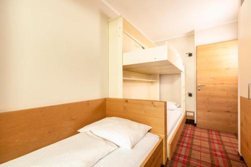 a small room with two beds and a bunk bed at Kinder- & Gletscherhotel Hintertuxerhof in Tux