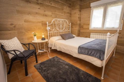 a bedroom with a bed and a chair and a table at Apartamentos Pumarin in Santa Marina