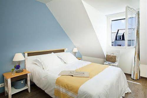 Un dormitorio con una cama grande y una ventana en Résidence Marie Galante Locmaria avec piscine en Locmaria