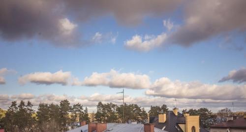 a cloudy sky with houses and trees and buildings at Apartament Augustów SWAN in Augustów