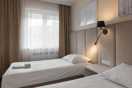a hotel room with two beds and a window at Apartamenty w Klaudynie in Klaudyn