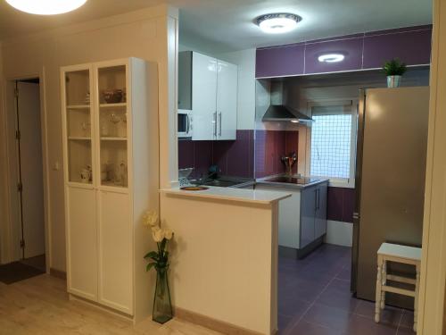 a kitchen with purple cabinets and a vase of flowers at Apartamento Cayetano in Ronda