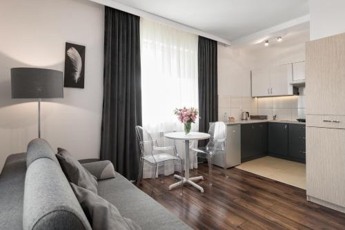 a living room with a couch and a table and a kitchen at Apartamenty w Klaudynie in Klaudyn