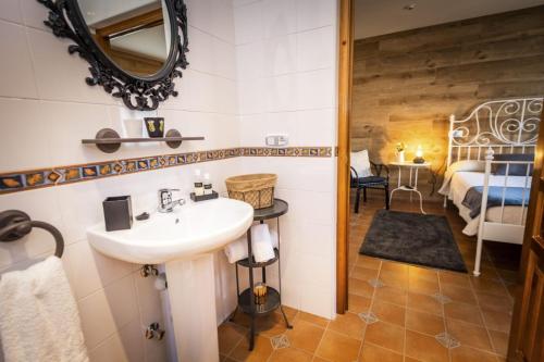 a bathroom with a sink and a bedroom at Apartamentos Pumarin in Santa Marina