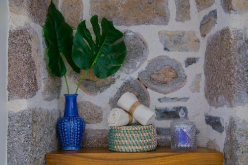 a blue vase sitting on a wooden shelf with a plant at Lithos Residence Poros in Poros