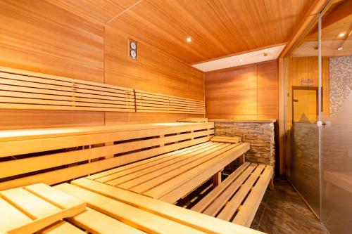 an empty sauna with wooden walls and wooden benches at Kinder- & Gletscherhotel Hintertuxerhof in Tux